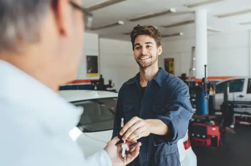 car mechanic giving back keys to customer