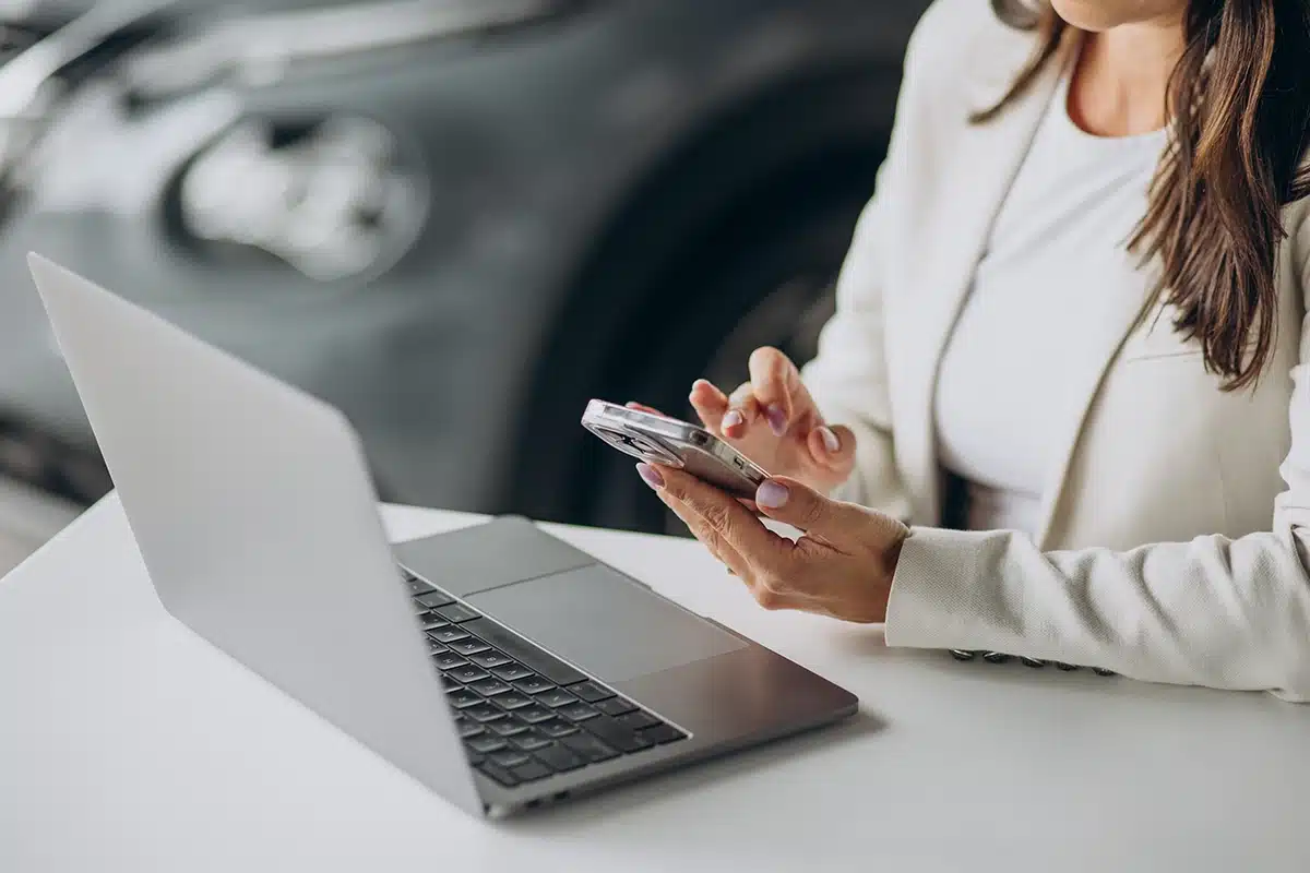 lady sitting at computer holding phone